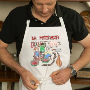 Delantal con un diseño artesanal dedicado a la matanza del cerdo.