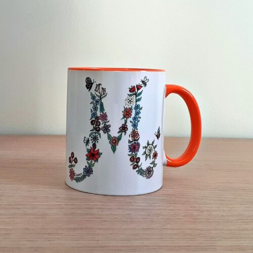Taza de cerámica de colores con una ilustración artesanal dedicada a diferentes iniciales