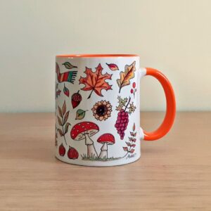 Taza de cerámica de colores con una ilustración artesanal dedicada al otoño