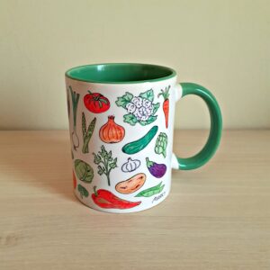 Taza de cerámica de colores con una ilustración artesanal dedicada a las verduras de la huerta.